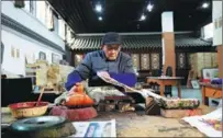  ?? ?? Guo Taiyun uses carving knives to turn woodblocks into printers of New Year paintings.