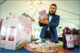  ?? PHOTOS BY WATCHARA PHOMICINDA — SOUTHERN CALIFORNIA NEWS GROUP ?? Rabbi Shmuel Fuss holds a Passover Seder guide from a to go kit during the coronaviru­s pandemic at Chabad Jewish Community Center of Riverside in Riverside on Thursday. The Jewish holiday of Passover begins today.