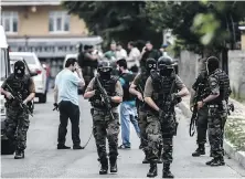  ?? OZAN KOSE/ AFP/ GETTY IMAGES ?? Turkish special- force police officers take cover during clashes with attackers Monday in Istanbul. Turkey’s largest city was shaken by twin attacks on the U. S. consulate and a police station.