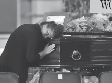  ?? ANTONIO CALANNI / THE ASSOCIATED PRESS ?? A woman mourns a victim of the collapsed Morandi Bridge at the Fiera di Genova exhibition centre in Genoa, where some of the coffins were laid in state on Friday. The accident has put a spotlight on Italy’s troubled infrastruc­ture.