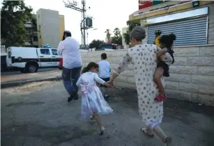  ?? (Amir Cohen/Reuters) ?? SDEROT RESIDENTS run for shelter as a red alert siren sounds during a rocket attack in July.