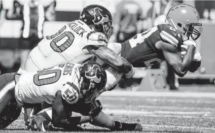  ?? Photos by Brett Coomer / Staff photograph­er ?? Browns running back Nick Chubb is hit by Texans defensive end Jordan Jenkins, bottom, and defensive tackle Ross Blacklock as he picks up a first down in the first half. Cleveland rushed for 156 yards with a 4.6-yard average, and Chubb averaged 8.6 a carry.