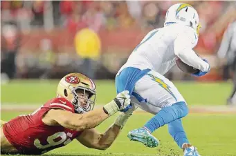  ?? Scott Strazzante/The Chronicle ?? The 49ers’ Nick Bosa pulls down Chargers wide receiver DeAndre Carter in the fourth quarter.