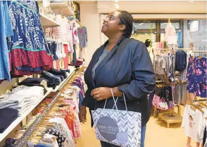  ?? BARBARA HADDOCK TAYLOR/BALTIMORE SUN ?? Kala Craig of Laurel shops for clothes for her daughter at the Wee Chic in Luthervill­e. Like other shoppers in the state, she is looking forward to Sunday, which starts Maryland Tax-Free Week.
