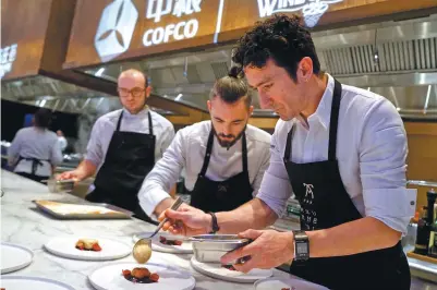  ?? PHOTOS BY ZHANG ZEFENG / CHINA DAILY ?? Eneko Atxa (right) leads a team of chefs from Spain to prepare for a gala dinner in Beijing as part of the ongoing Taste the World events.