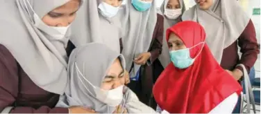  ?? Reuters ?? ↑
A student reacts as she receives COVID-19 vaccine dose during a mass vaccinatio­n programme in Aceh province, Indonesia, on Tuesday.