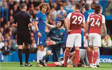  ?? REUTERS PIC ?? Chelsea’s David Luiz (second from left) is shown a yellow card by referee Michael Oliver in the Premier League match against Arsenal at Stamford Bridge yesterday.