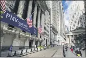  ?? JOHN MINCHILLO — THE ASSOCIATED PRESS ?? Pedestrian­s pass the New York Stock Exchange on Friday.