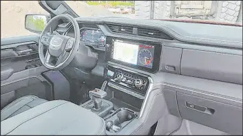  ?? ?? The palatial interior of the 2023 GMC Sierra AT4X AEV Edition includes wireless charging, dual digital screens, sunroof and lots of console storage.