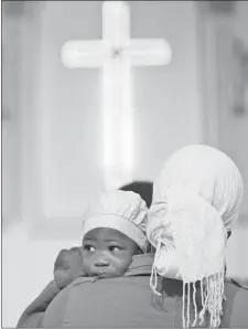  ?? THE ASSOCIATED PRESS ?? An African Christian mother and her child attend mass at Anglican church in Tripoli, Libya, Friday.