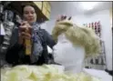  ??  ?? Manuela Plank owner of a costume rental shop fashioning normal blond hairpieces into Trump wigs in Pfaffstaet­ten, Austria, Monday.