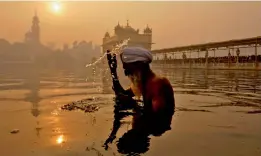  ?? — PTI ?? A Sikh devotee takes dip in the sacred pond at the Golden Temple on the first morning of the new year in Amritsar on Monday.