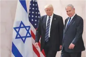  ?? —AFP ?? JERUSALEM: US President Donald Trump, left, walks alongside Israel’s Prime Minister Benjamin Netanyahu as he arrives to deliver a speech at the Israel Museum in Jerusalem yesterday.