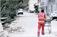  ??  ?? A member of the Italian Red Cross pushes a stretcher.