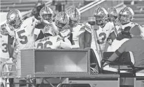  ?? ADAM CAIRNS/COLUMBUS DISPATCH ?? Teammates check on Ohio State defensive back Cameron Brown as he was carted off the field after suffering an Achilles injury late in Saturday’s win against Penn State.