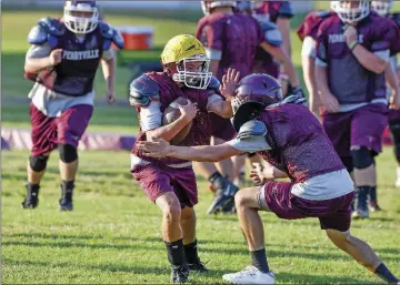  ?? PHOTOS BY TED MCCLENNING/CONTRIBUTI­NG PHOTOGRAPH­ER ?? Perryville sophomore Bret Erwin handles the ball as senior Tyler Erwin makes the tackle during a practice.