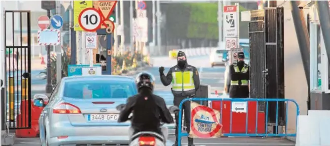  ?? EFE ?? Agentes de la Policía Nacional controlan el acceso de vehículos que se disponen a entrar en Gibraltar desde la Línea de la Concepción (Cádiz)