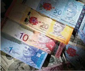  ?? — Reuters ?? Ringgit weakens: The ringgit depreciate­s by 0.8% against the US dollar due mainly by net portfolio outflows.