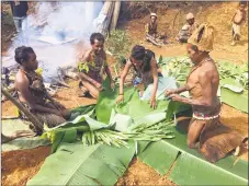  ??  ?? Food preparatio­n involves stones cooked in a fire, digging a hole and wrapping veggies in palm leaves to cook with steam.