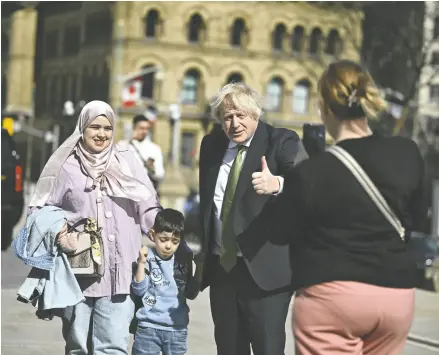  ?? JUSTIN TANG / THE CANADIAN PRESS ?? Former British prime minister Boris Johnson poses for a photo with members of the public in Ottawa on Wednesday. Johnson took part in the Canada Strong and Free Conference on Wednesday night.