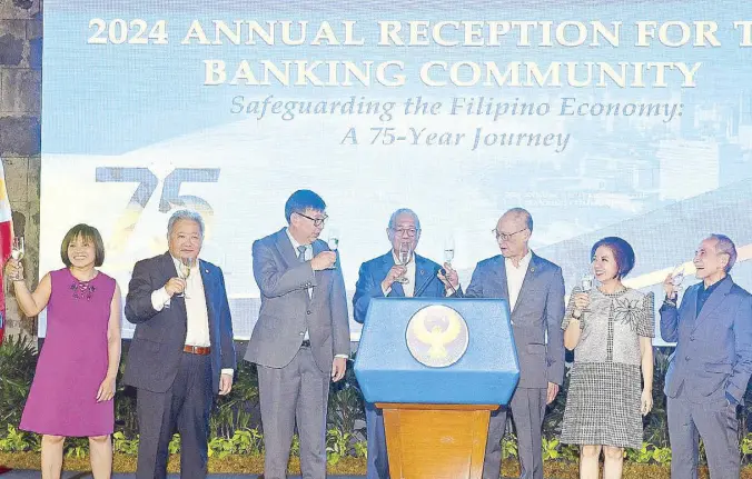  ?? ?? BSP Governor Eli Remolona Jr. (center) leads Monetary Board Members Rosalia de Leon, Bruce Tolentino, Finance Secretary Ralph Recto, Benjamin Diokno, Romeo Bernardo and Anita Aquino to a toast during the 2024 Annual Reception for the Banking Community.