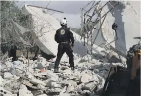  ?? AFP ?? A member of the Syrian Civil Defence (White Helmets) searches for victims of an air strike that hit the village of Jaballa in the south of the Idlib region yesterday.
Six civilians including a child were killed