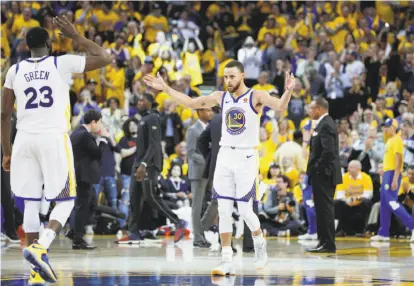  ?? Carlos Avila Gonzalez / The Chronicle ?? Stephen Curry gestures for more noise from the crowd as Draymond Green prepares for a high-five during a patented Warriors third-quarter blitz in Game 5 of the Western Conference semifinals against New Orleans.