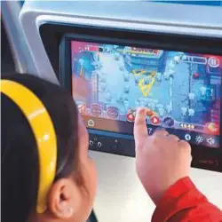  ?? AFP ?? A child plays a game on a touch-screen onboard the Tejas Express during its first journey between Mumbai and Goa in Mumbai. The Tejas Express takes eight and a half hours to reach Goa, only marginally quicker than regular services, though it is capable...