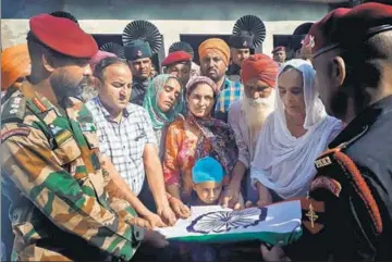  ?? PTI ?? ■ Army officers hand over the Tricolour wrapped around the body of Lance Naik Sandeep Singh to his family members after his cremation at Kotla Khurd village in Gurdaspur on Tuesday.