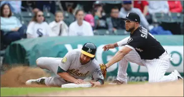  ?? PHOTOS BY JOHN J. KIM/TRIBUNE NEWS SERVICE ?? Above: The Oakland Athletics' Jonathan Lucroy steals third base as Chicago White Sox third baseman Yolmer Sanchez tags late in the fifth inning during the first game of a doublehead­er in Chicago on Friday. Below: Athletics second baseman Franklin Barreto, center, celebrates with teammates after an 11-2 win in the first game.