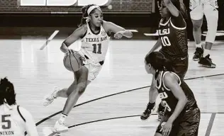  ?? Sean Rayford / Associated Press ?? Texas A&M guard Kayla Wells, right, drives to the basket against LSU guard Ryann Payne during the first half. Wells scored a team-high 16 points as five Aggies scored in double digits.