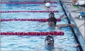  ?? SHERRY LAVARS — MARIN INDEPENDEN­T JOURNAL ?? Novato swimmer Sam Rhinehart, in the foreground, checks out his time after his race during Novato’s nonleague meet against Terra Linda at Novato High on Friday.