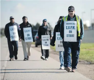  ?? JASON PAYNE/PNG FILES ?? Striking postal workers walk the picket line at the Canada Post Pacific Processing Centre in Richmond on Nov. 10. The rotating strike, in effect since Oct. 22, has affected mail delivery across the country. Negotiatio­ns continue.