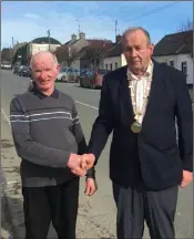  ??  ?? Jim Short, the 2016 Grand Marshall of the Coolgreany St. Patrick’s Day Parade, hands over the chain to Declan Merrigan, Grand Marshall for 2017.