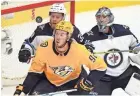  ?? THE TENNESSEAN ?? Predators center Ryan Johansen (92), Jets defenseman Toby Enstrom (39) and Jets goalie Connor Hellebuyck (37) eye the puck during the second period of Game 1 on Friday. GEORGE WALKER IV /