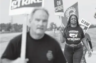  ?? Paul Sancya / Associated Press ?? United Auto Workers members walk on the picket line during a strike at General Motors Orion Assembly plant in Orion Township, Mich. The strike is in its third week.