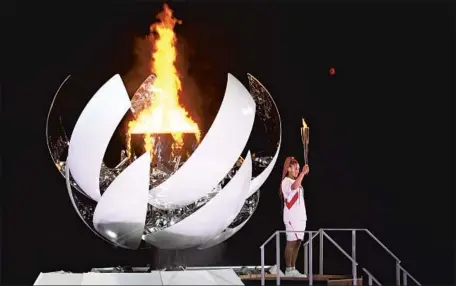  ?? Wally Skalij Los Angeles Times ?? TENNIS STAR Naomi Osaka, a four-time Grand Slam singles champion, lights the cauldron during the opening ceremony in Tokyo.