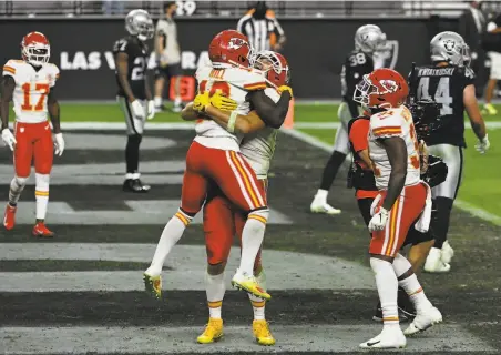  ?? David Becker / Associated Press ?? Chiefs tight end Travis Kelce embraces wide receiver Tyreek Hill after Kelce scored the winning touchdown against the Raiders.