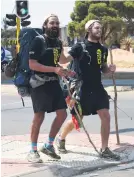  ?? Sibanda Picture: Nigel ?? NEARLY THERE. Tom David, left, and Warren Handley walk along Katherine Street in Johannesbu­rg as they end the Lonely Road Challenge to raise money for vulnerable children and orphans.