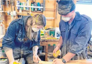  ?? CONTRIBUTE­D ?? Bosun Heather Smith, left, and deckhand Chris Greenlaw work on sanding and varnishing Bluenose II'S smaller spars..