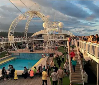  ?? KATHLEEN KINNEY ?? Cruisers enjoy the sunset by the pool on P&O’s Pacific Jewel.