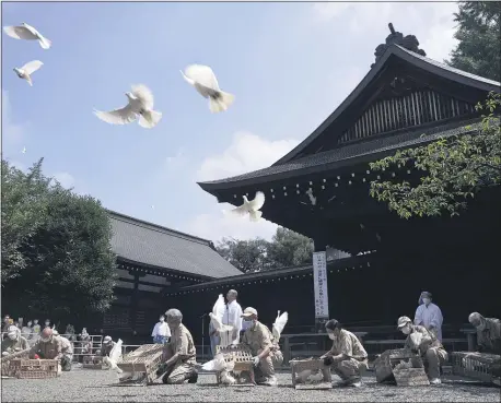  ?? EUGENE HOSHIKO - STAFF, AP ?? Employees release doves, wishing for the world’s peace and paying respects to the war dead at Yasukuni Shrine Saturday, Aug. 15, 2020, in Tokyo. Japan marked the 75th anniversar­y of the end of World War II.