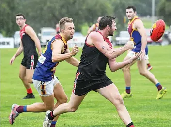  ?? Photograph­s by CRAIG JOHNSON. ?? Warragul coach Jed Lamb (right) gets a handball away ahead of Moe’s Scott van Dyk.