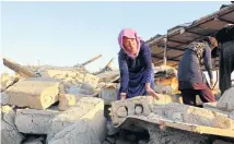  ??  ?? Iranian women clear rubble from earthquake-damaged buildings in Kalaleh village, Kermanshah province, Iran on Tuesday.