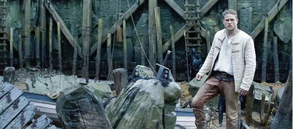  ?? Foto: Warner Bros. ?? In düsteren Welten: Der junge, zum König bestimmte Arthur (Charlie Hunnam) wird das Excalibur Schwert aus dem Granit ziehen.