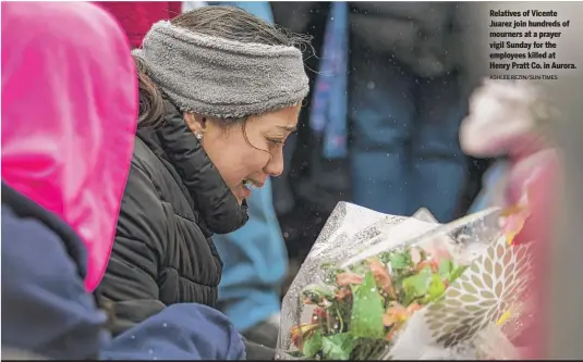  ?? ASHLEE REZIN/SUN-TIMES ?? Relatives of Vicente Juarez join hundreds of mourners at a prayer vigil Sunday for the employees killed at Henry Pratt Co. in Aurora.