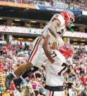  ?? REBECCA BLACKWELL AP ?? Georgia running back Kendall Milton (2) is lifted up by lineman Xavier Truss (77) after scoring a touchdown.