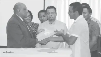  ??  ?? Minister of Natural Resources, Raphael Trotman (left), handing over a signed copy of the MoU to the Chairman on the National Toshaos Council, Nicholas Fredericks.