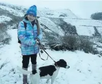  ??  ?? ●● Dotty Davies, 12, with rescue dog Artemis enjoying the snow in Rossendale