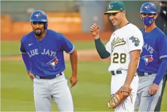  ?? Scott Strazzante / The Chronicle ?? Toronto second baseman Marcus Semien shares a lightheart­ed moment at first base with his exteammate, Matt Olson, after a secondinni­ng walk. Semien spent six seasons with the A’s.